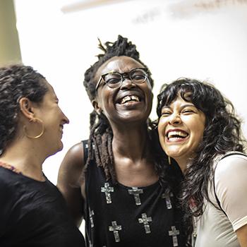 Three women joyously hugging