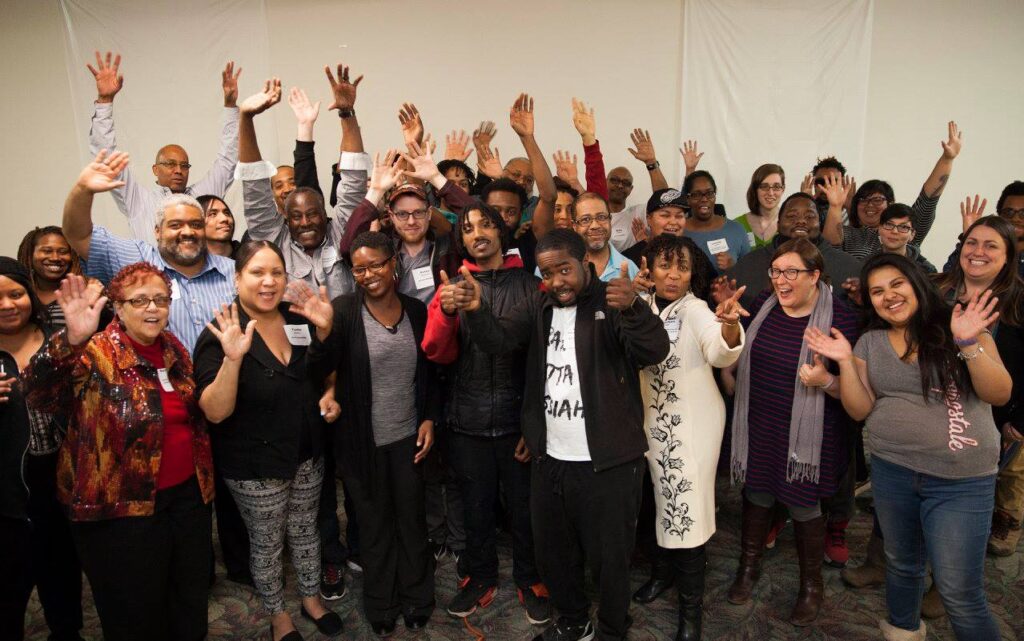 Digital Stewards participants at launch close in a group smiling with hands in the air