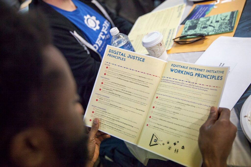 Close up over the shoulder of a Digital Steward reading through a booklet of the Digital Justice Principles