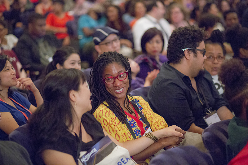 Two people in the audience at an auditorium of the AMC