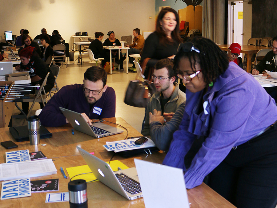 A group of people at a discotech, collaborating on laptops