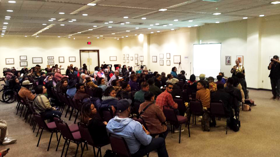View from the back of a large room with attendees of a Detroit Narrative Agency info session for the Seed Program