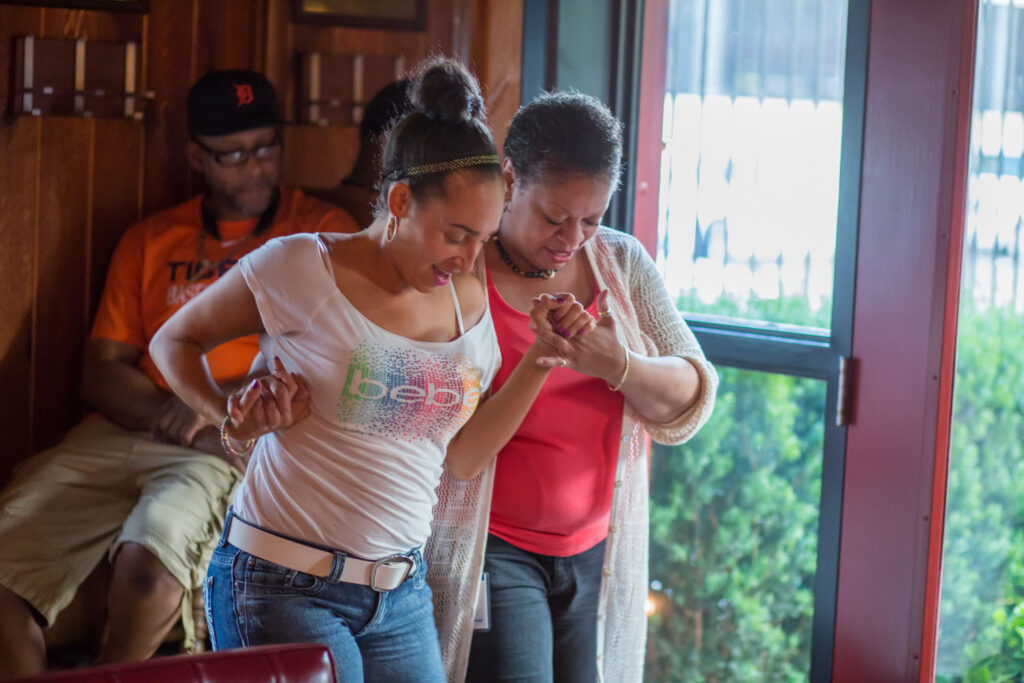 Two women AMC attendees dancing together