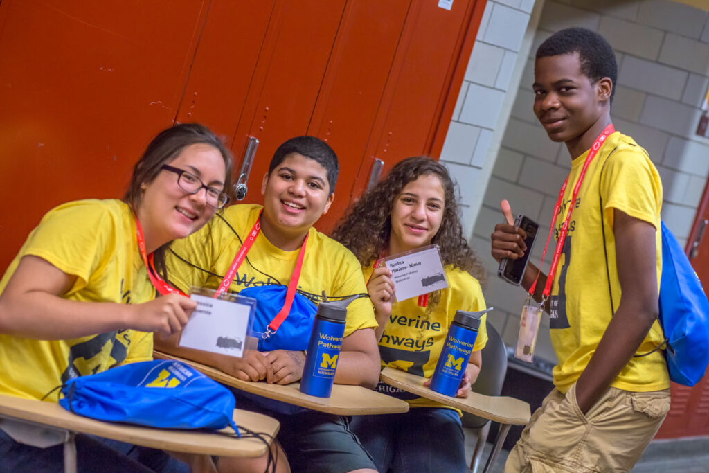 Four attendees of the AMC from the University of Michigan wearing matching yellow shirts