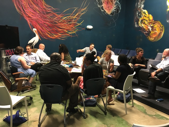 12 people in a small theater sitting in pairs talking to each other in a storytelling workshop