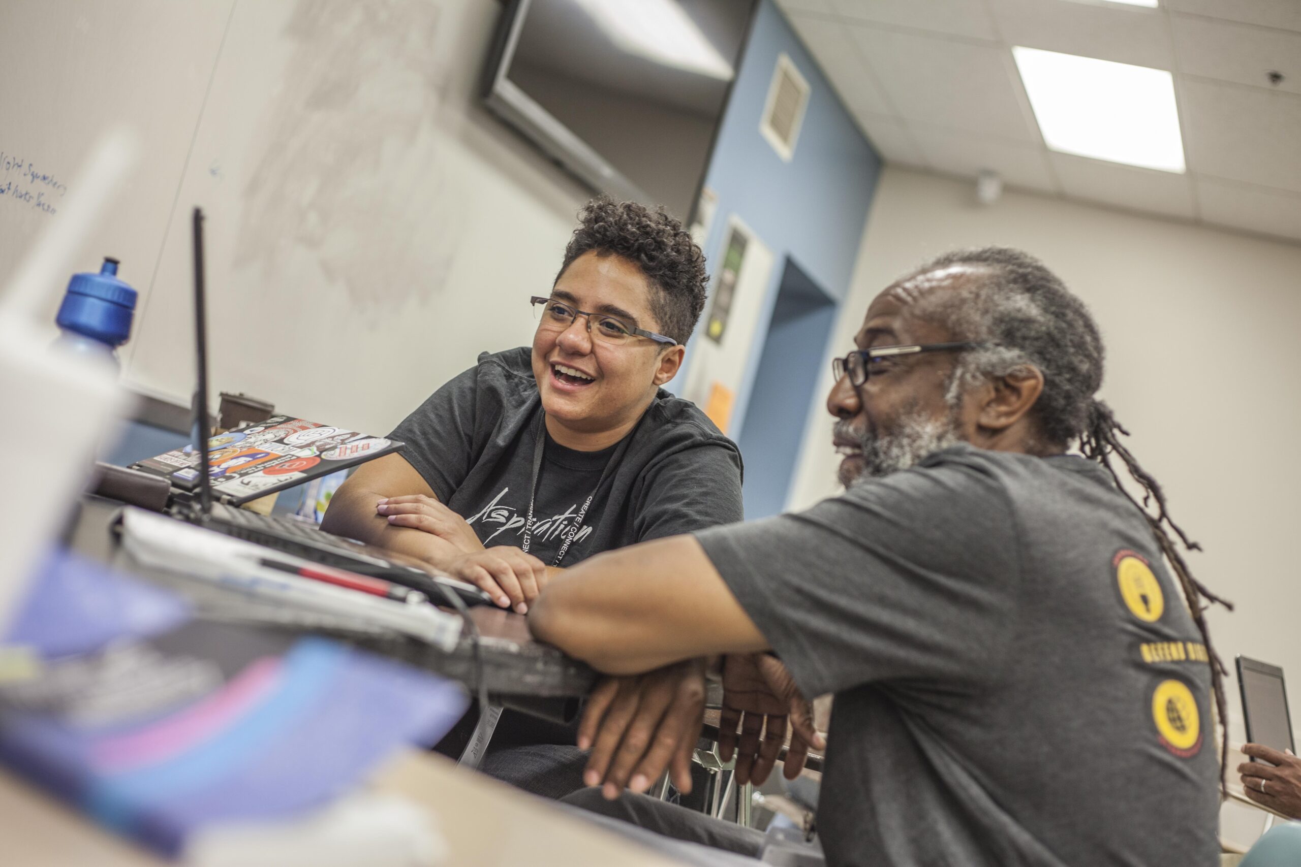 Two people engaged in intergenerational computer work