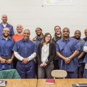 A large group of Hamtramck Free School members standing behind a table