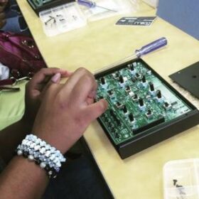 hands working on an electronic instrument