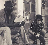 Man reading, being recorded by guy with mic