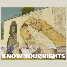 Street art on a wall with a scroll of the names of people killed by police with the title "Know Your Rights"